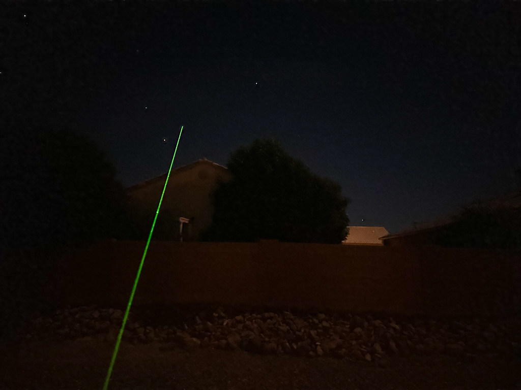 Green laser pointer in night sky